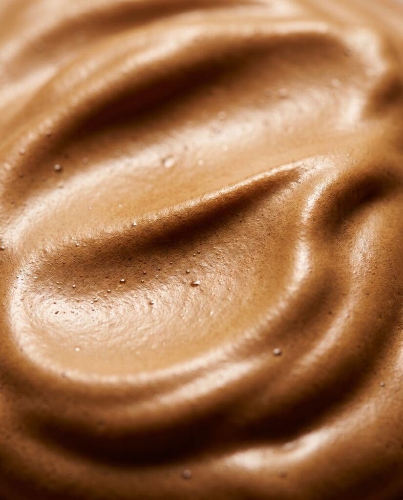 Close up of a bronze spray tan formula to avoid orange spray tan outcome.